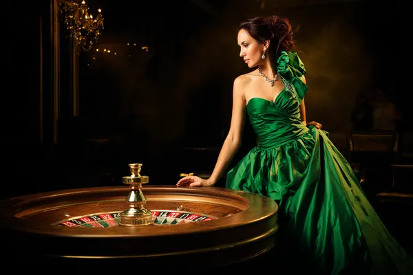 A stylish woman beside vibrant slot machines displaying glowing sevens, showcasing the variety of top slots at MC888.