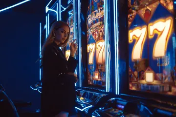 A woman smiling by bright slot machines showing lucky symbols, showcasing the exciting slot offerings at MC888.